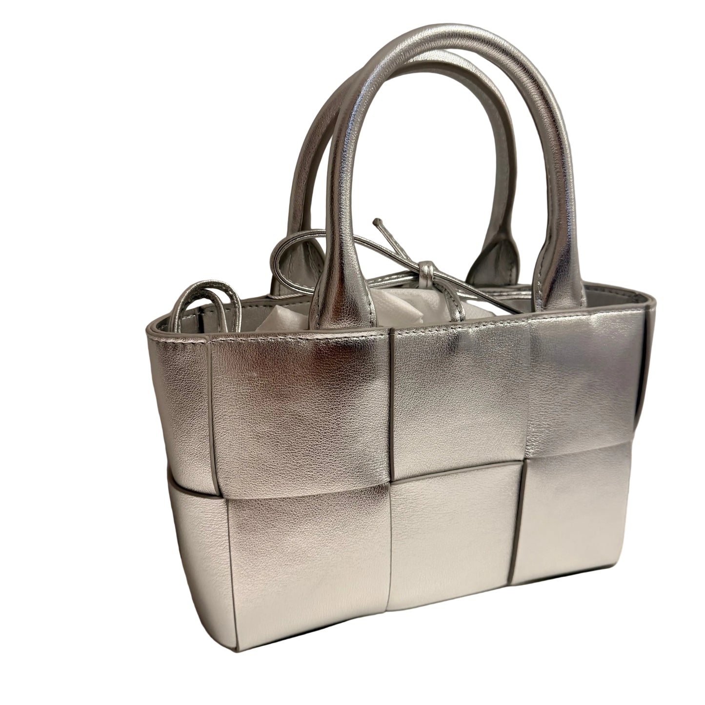 Silver quilted handbag on a neutral background