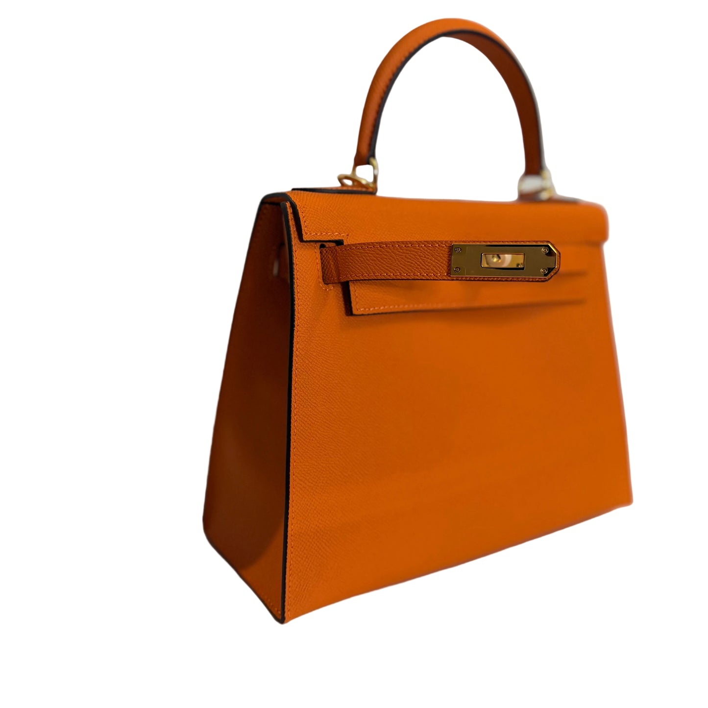 Orange handbag with gold hardware on a light gray background