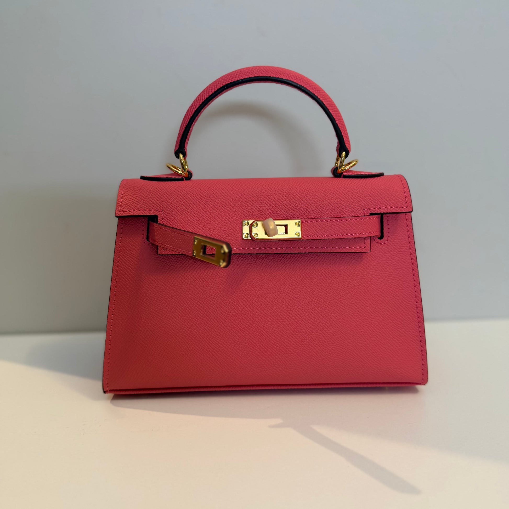 Red handbag with a gold clasp on a light gray background
