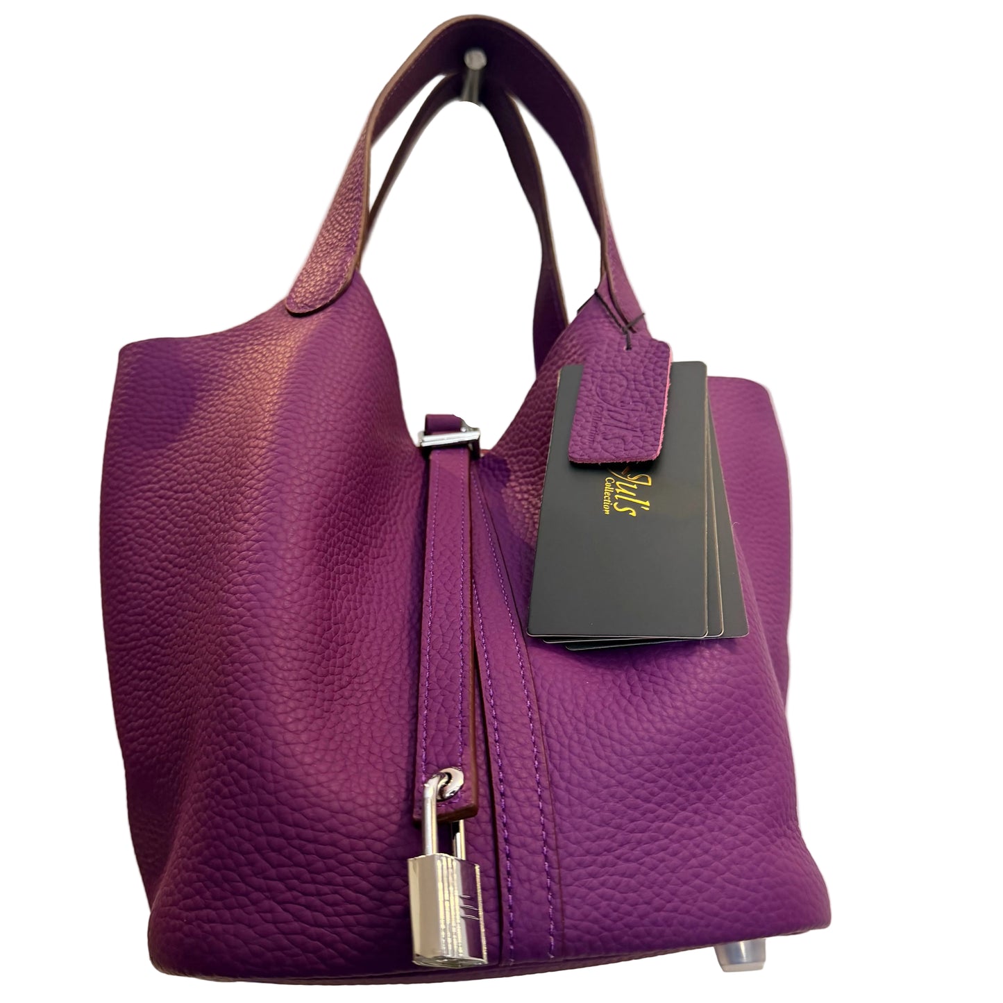 Purple handbag with a visible brand tag on a neutral background