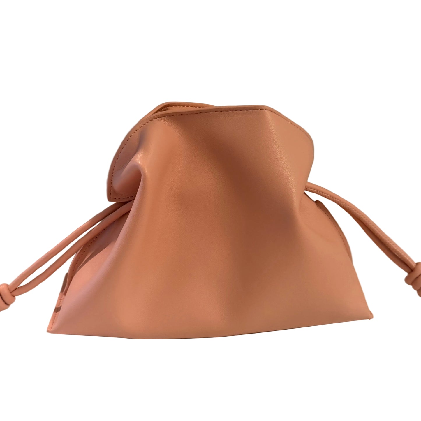 Tan leather drawstring bag on a light surface with a neutral background
