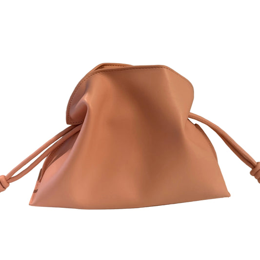 Tan leather drawstring bag on a light surface with a neutral background