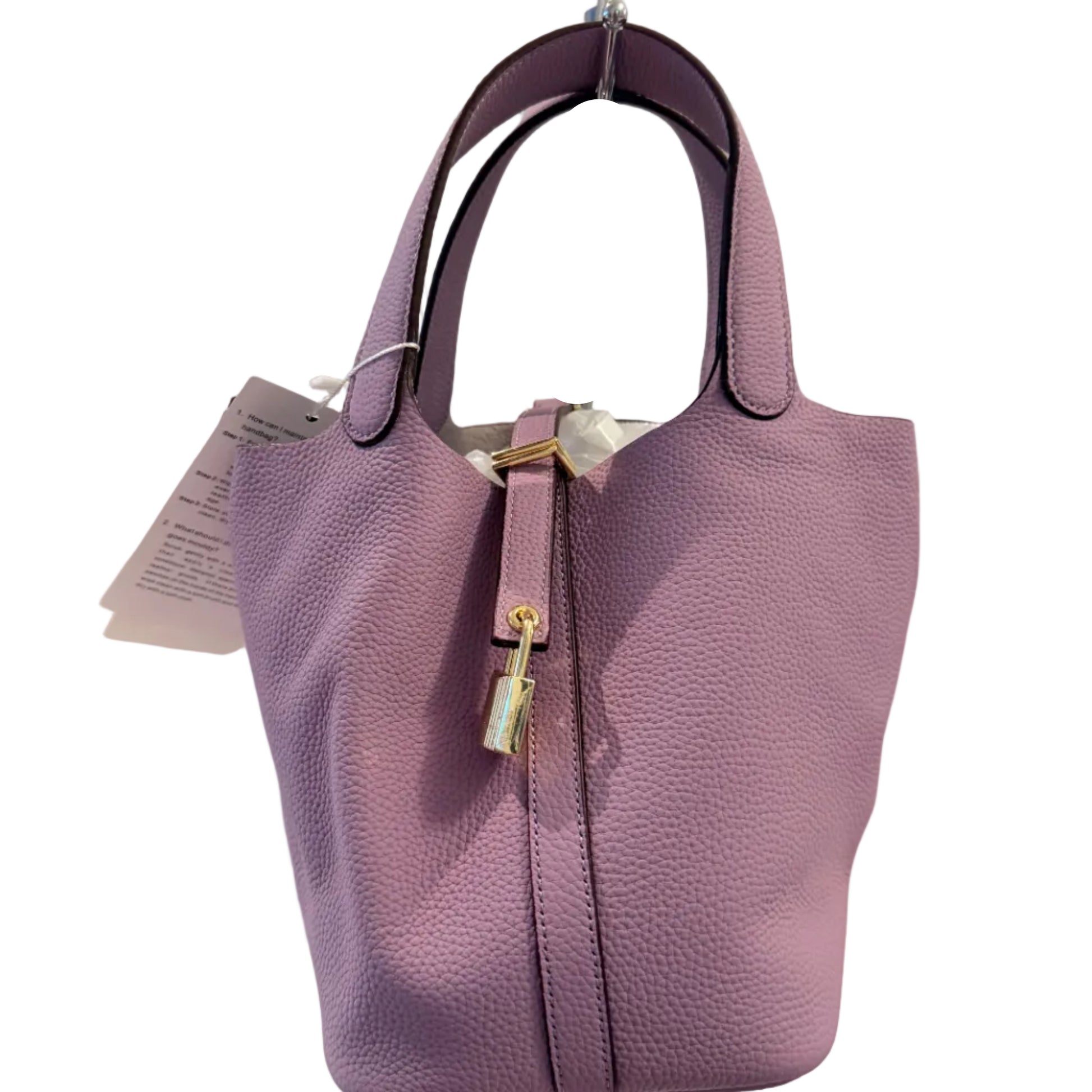 Purple handbag with a visible tag on a light gray background