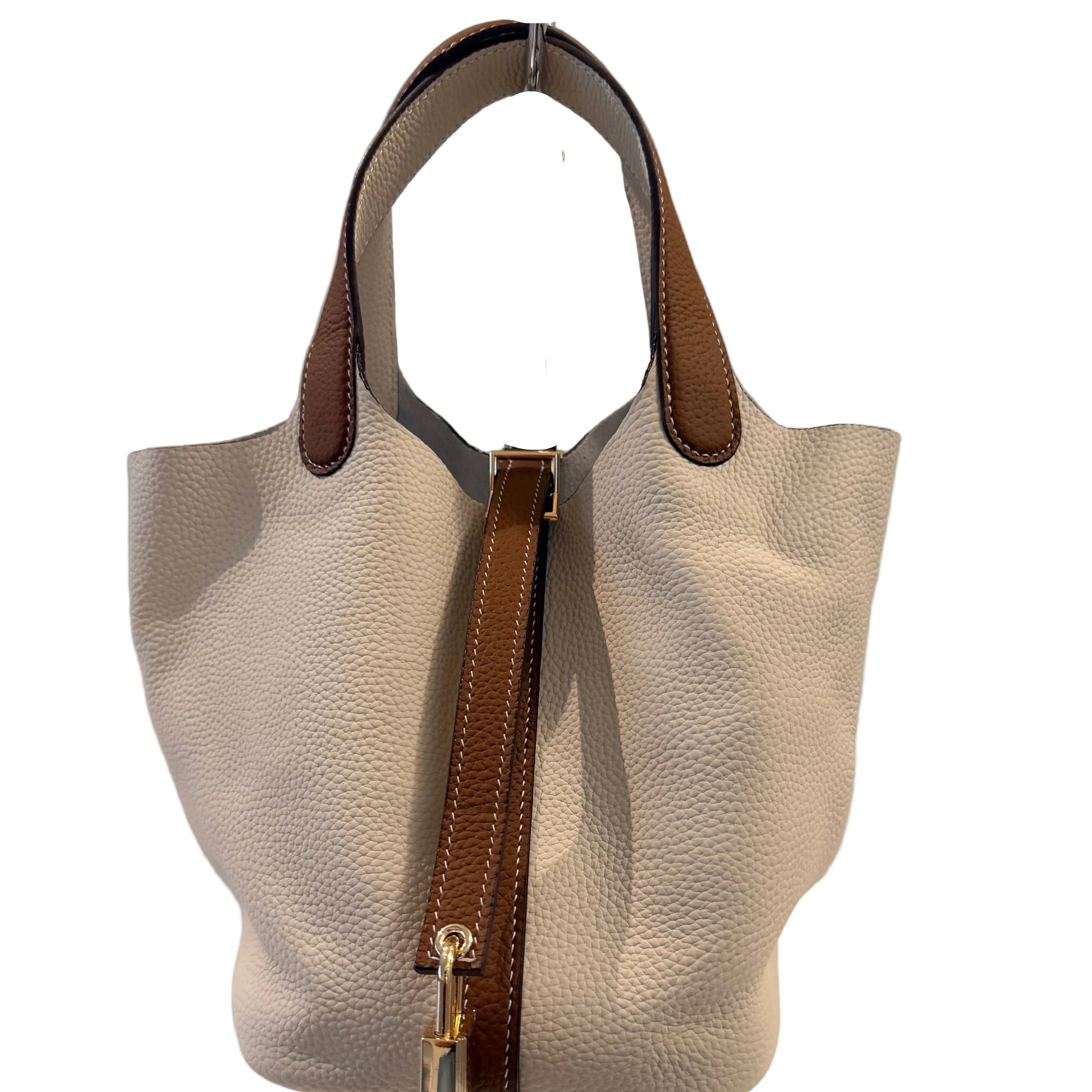 Beige handbag with brown accents on a white surface against a gray background