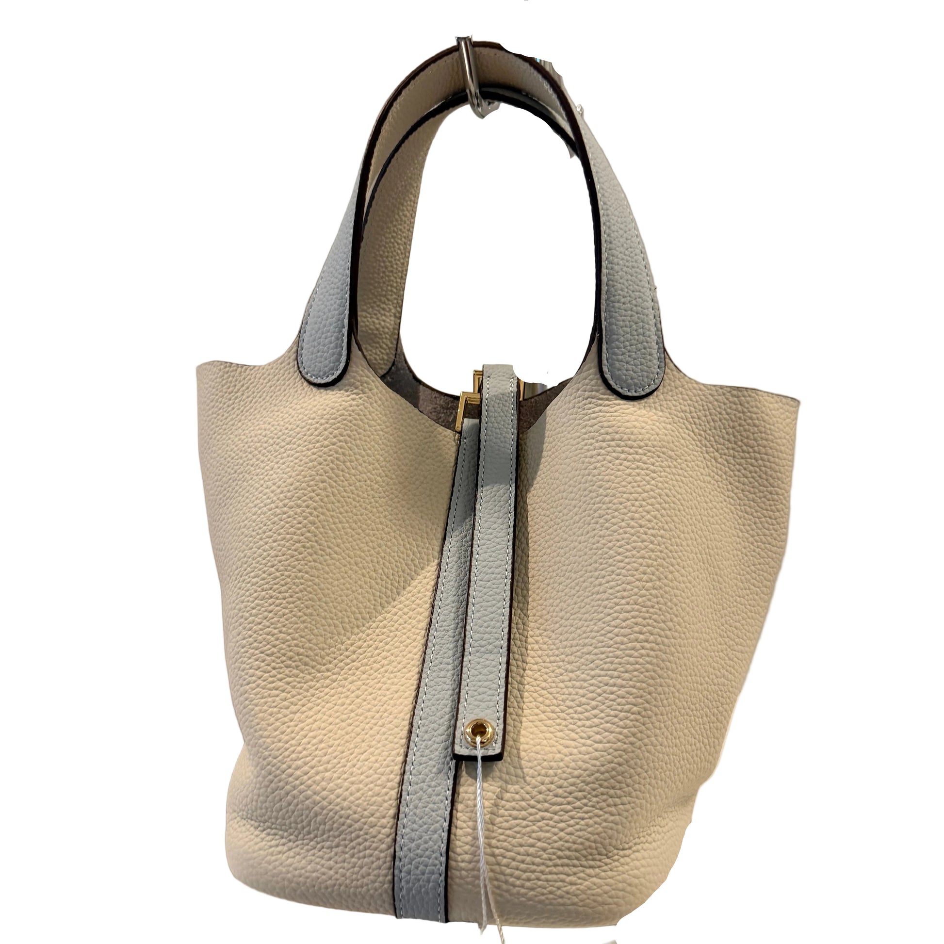 Beige handbag with a black strap on a gray background