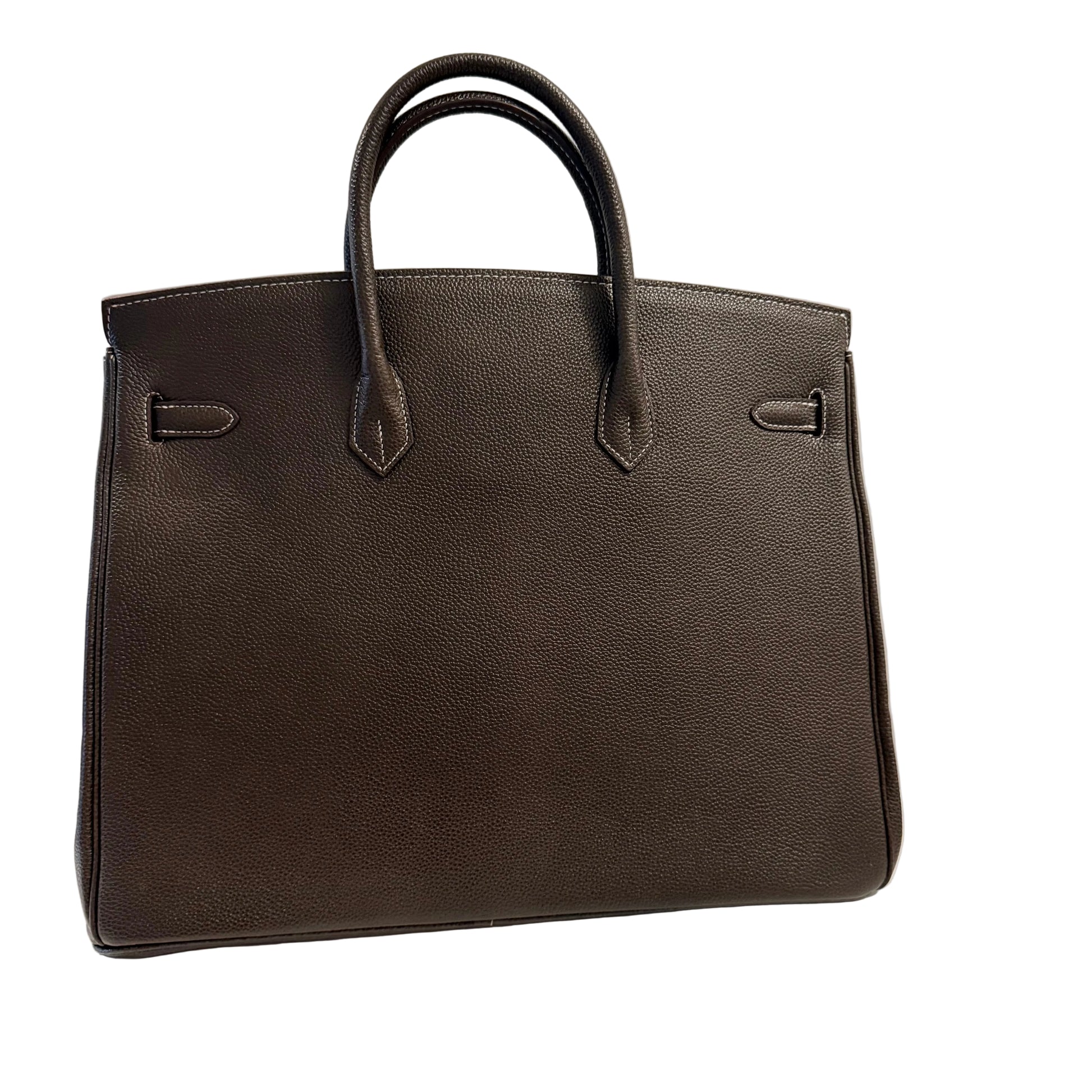 Brown leather handbag on a white surface with a light gray background