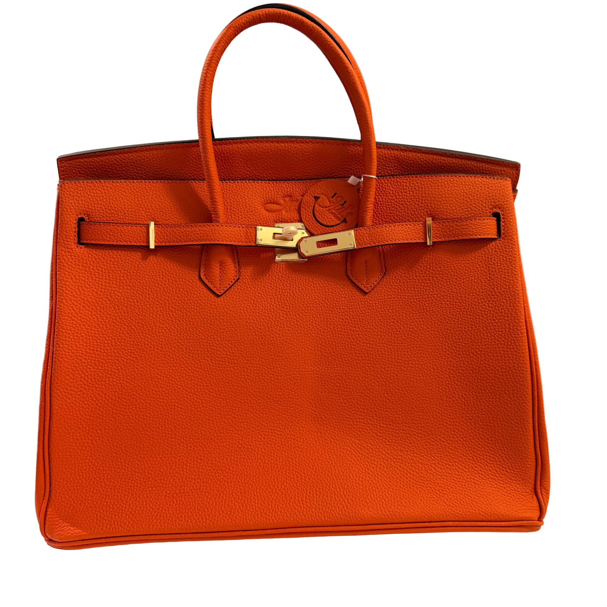Orange leather handbag with gold hardware on a neutral background
