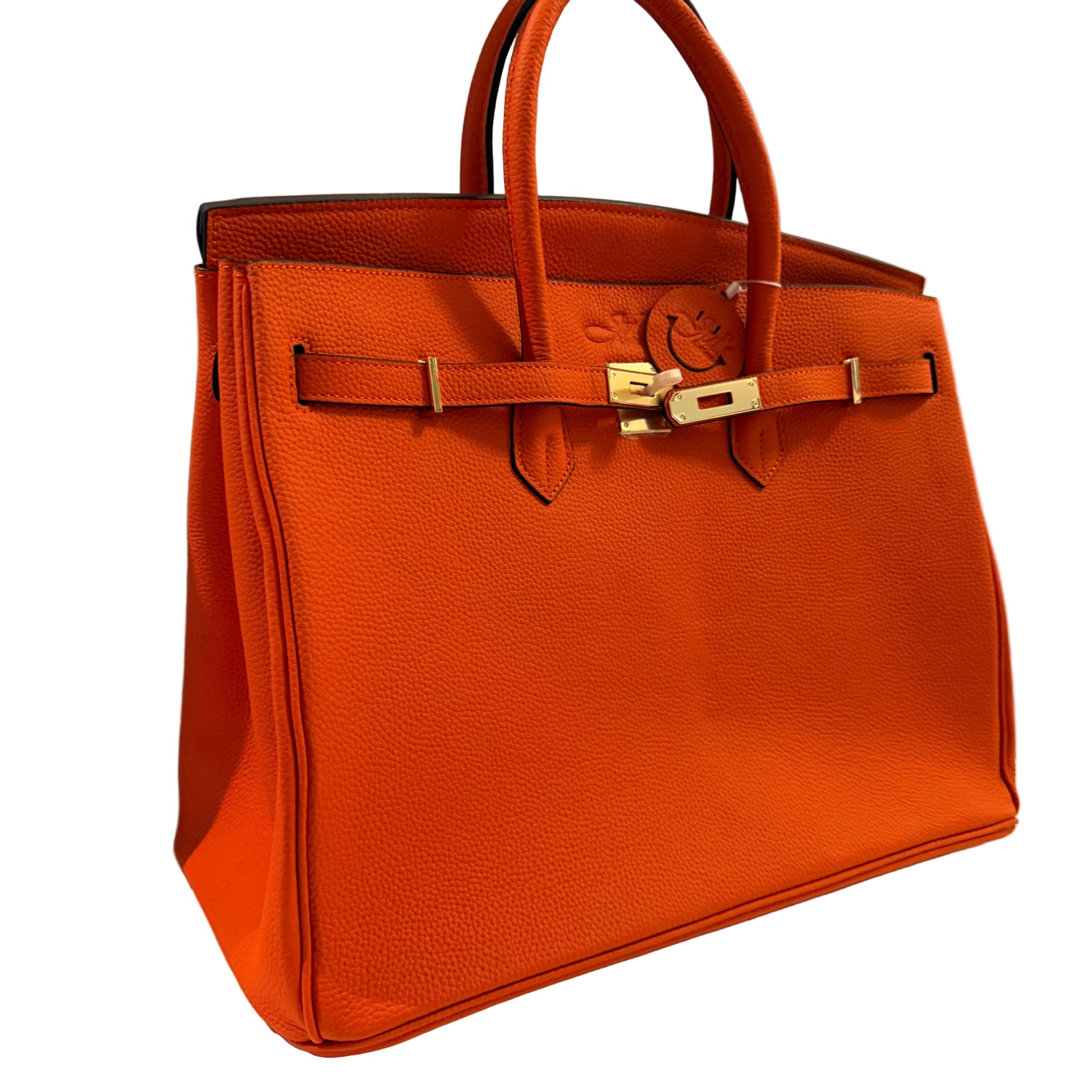 Orange handbag with gold hardware on a neutral background