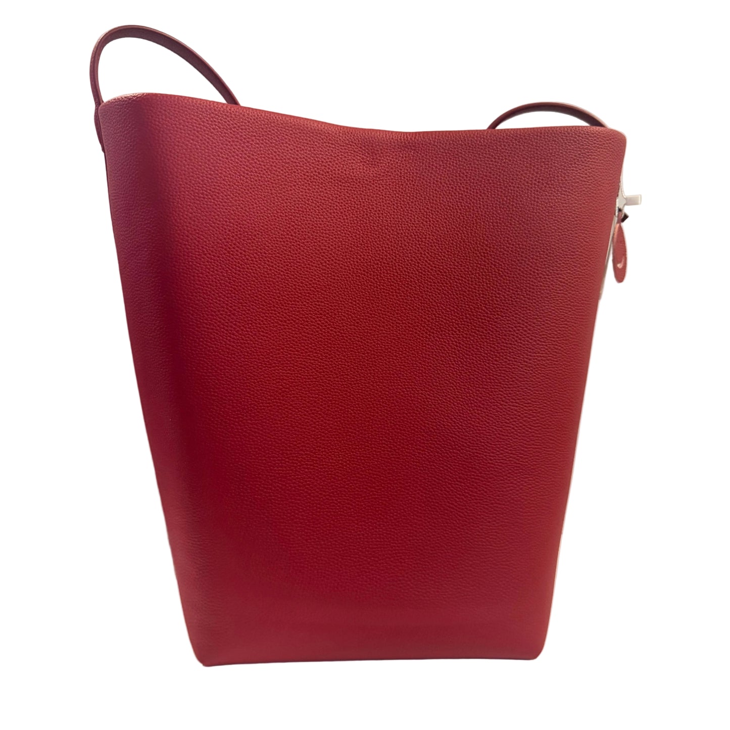 Red leather handbag on a white surface with a light gray background