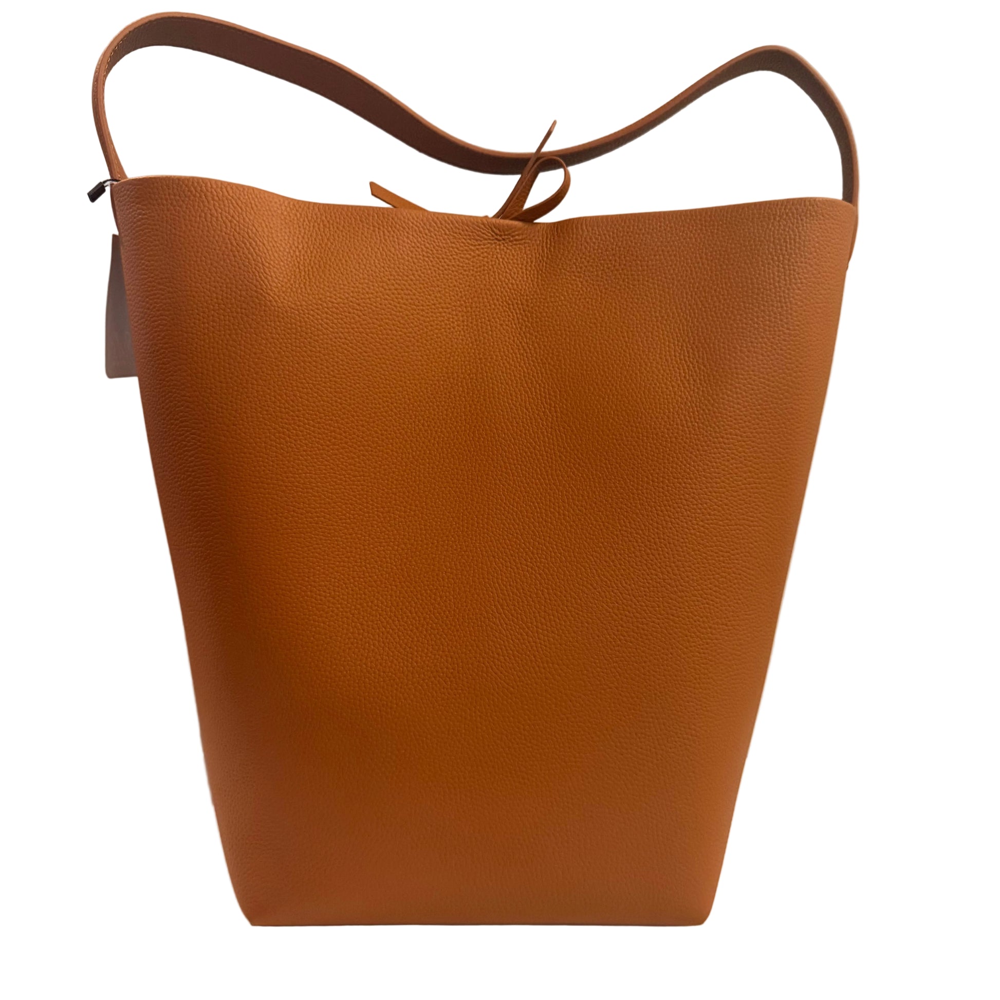 Brown leather tote bag on a white surface with a neutral background