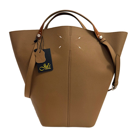 Brown leather handbag with a visible brand tag on a neutral background