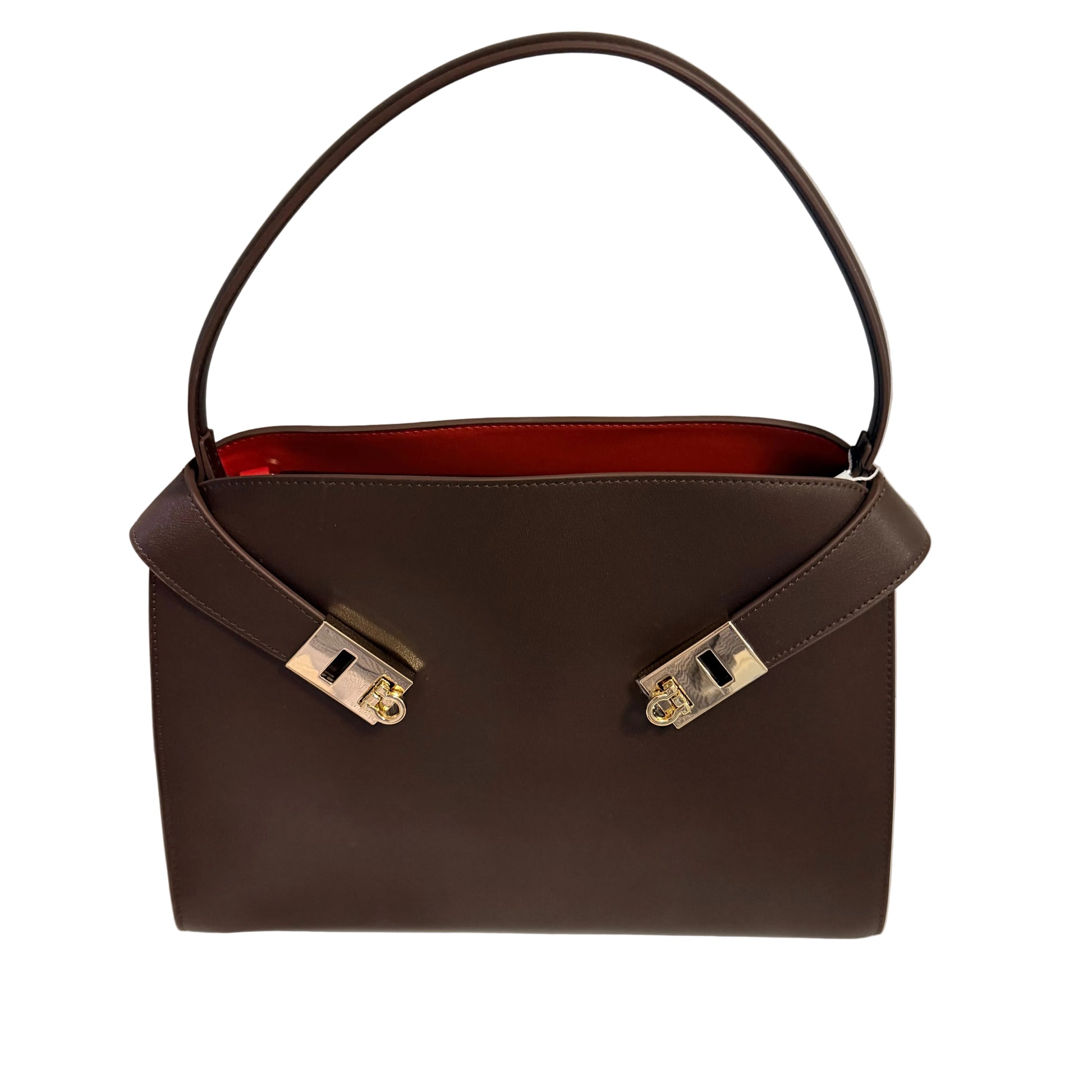 Brown handbag with gold hardware on a white surface and light gray background