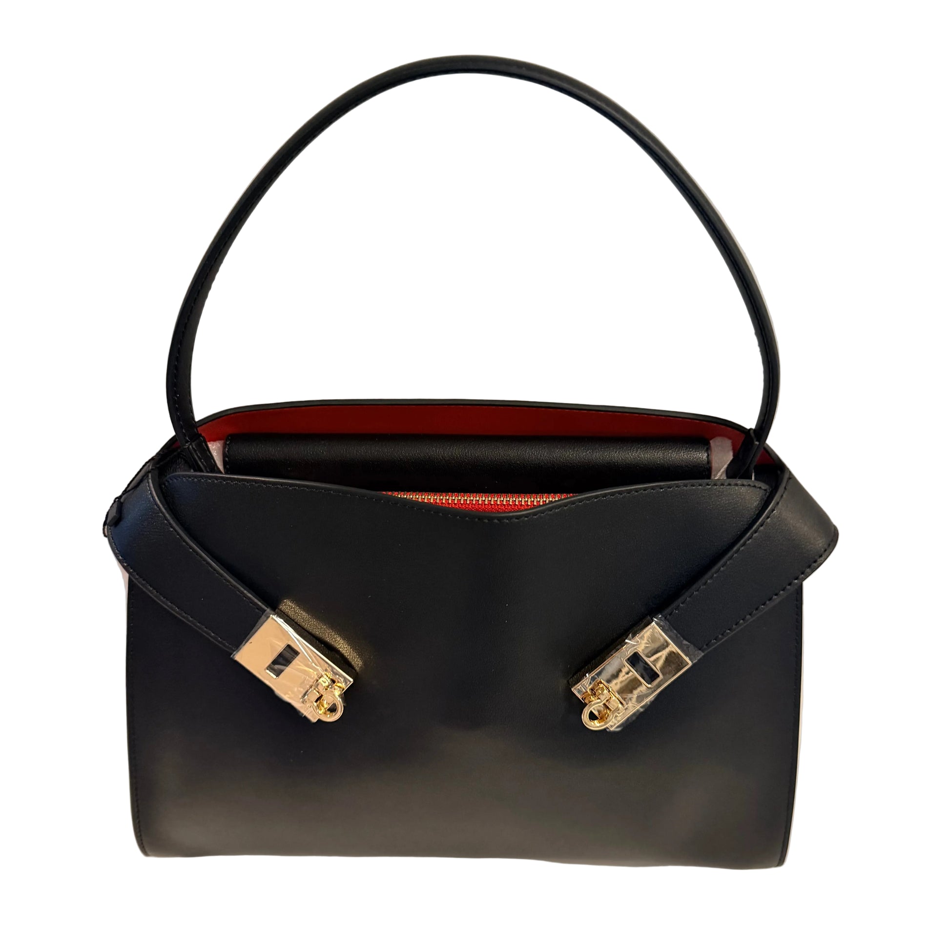 Black handbag with gold hardware on a light gray background
