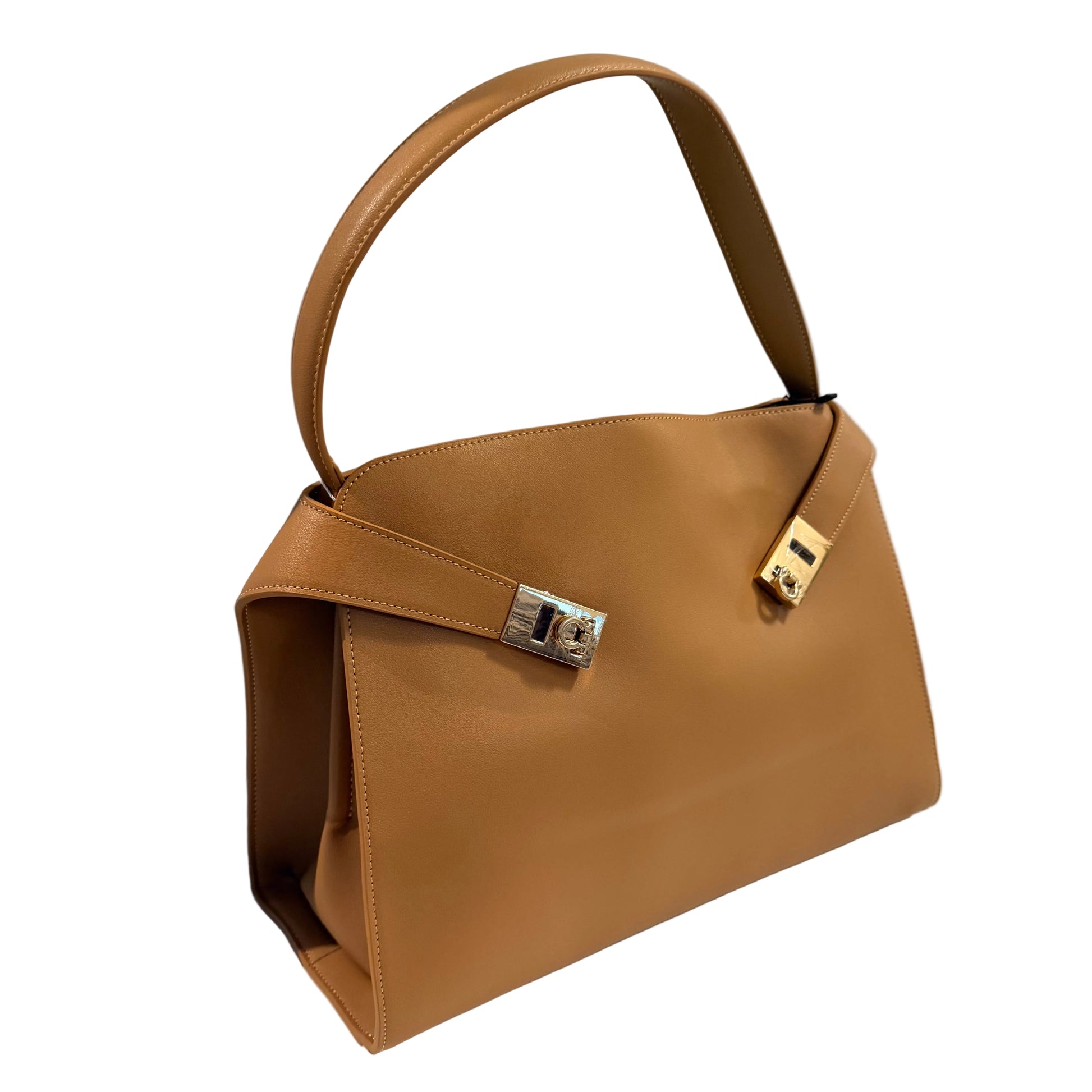 Brown handbag with a gold clasp on a white surface against a gray background