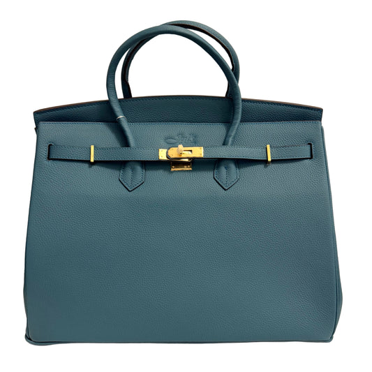 Blue handbag with gold hardware on a beige background