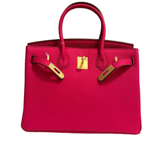 Pink handbag with gold hardware on a neutral background