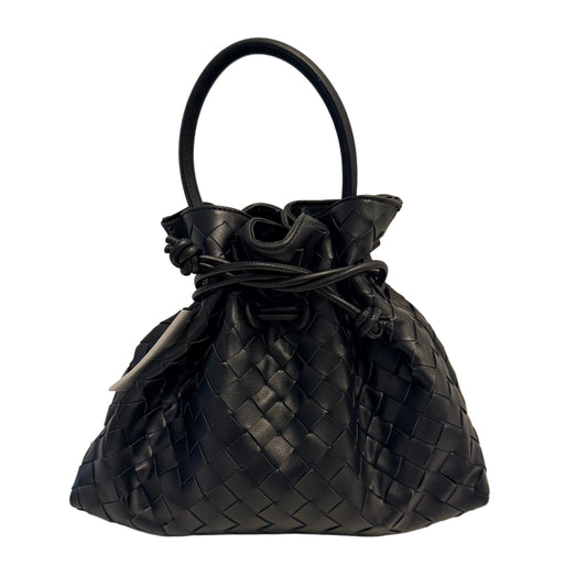 A black woven leather bucket bag with a single top handle, gathered drawstring, and a textured basketweave pattern, photographed against a plain light gray background.