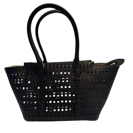 A black leather handbag with a perforated cutout pattern, featuring two top handles and a zippered top closure, set against a plain light background.