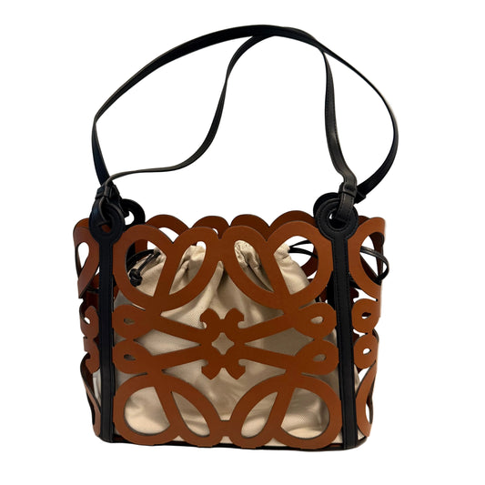 A structured shoulder bag with a brown laser-cut metal body and black leather straps, shown on a white surface against a plain white background.