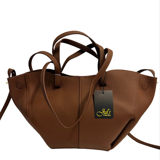 A brown pebbled leather handbag with double shoulder straps and a black hangtag, displayed on a white surface against a light gray background.