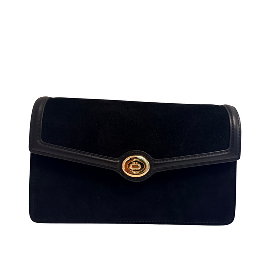 A black velvet envelope clutch bag with black leather trim and a gold-tone circular clasp, shown against a plain white background.