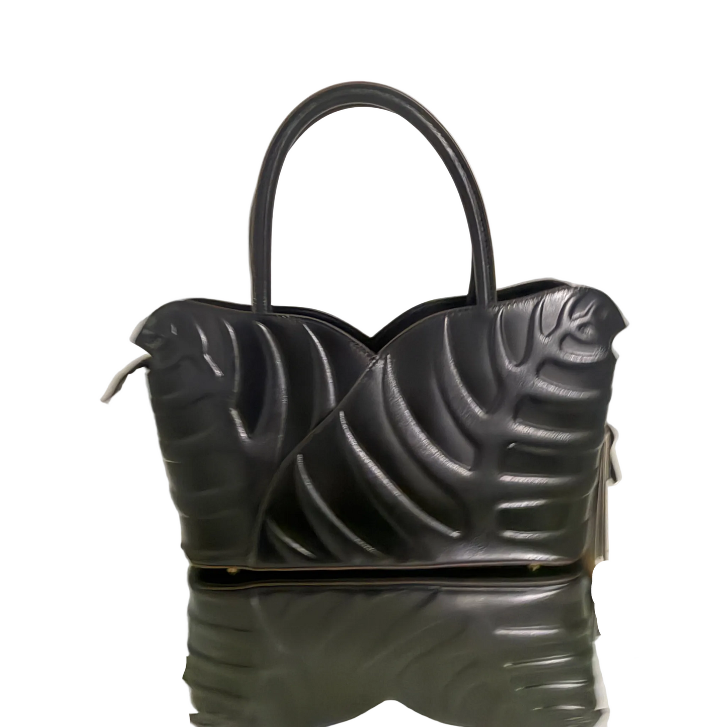 Black handbag with unique design on a reflective surface