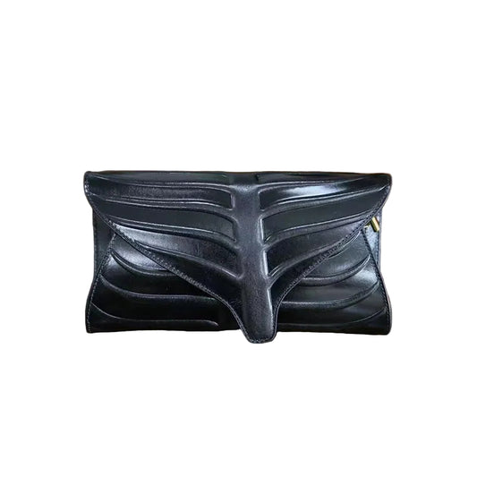 Three leaf-shaped clutches in green, brown, and red colors, displayed on a wooden surface.