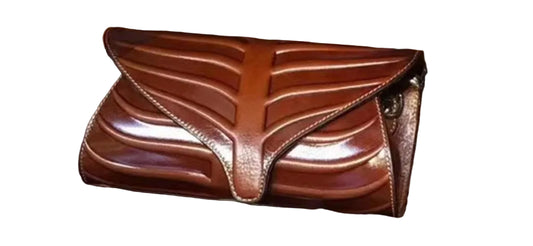 Three leaf-shaped clutches in green, brown, and red colors, displayed on a wooden surface.